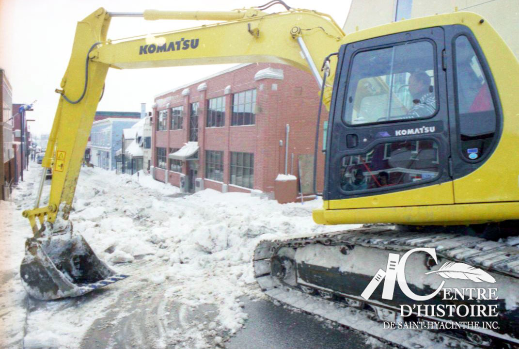 De la machinerie lourde est nécessaire afin de briser la glace accumulée dans les rues. Ici, on dégage la rue Girouard Ouest à l'angle de la rue Sainte-Anne.